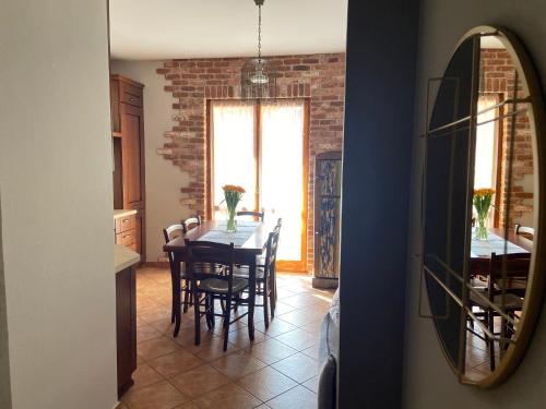 a dining room with a table and chairs and a mirror at Casa Luisini in Mondovì