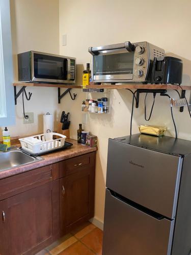 a kitchen with a refrigerator and two microwaves at Holualoa bungalow 1 in Kailua-Kona