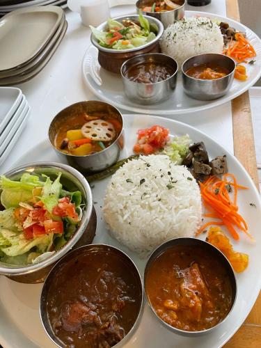 a table topped with plates of food with rice and vegetables at 南紀くまのいえ-WAKAYAMA・古座- in Kushimoto