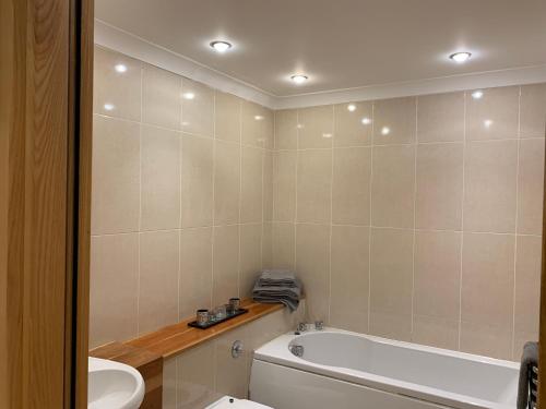 La salle de bains est pourvue d'une baignoire, de toilettes et d'un lavabo. dans l'établissement Killarney Town Apartment, à Killarney