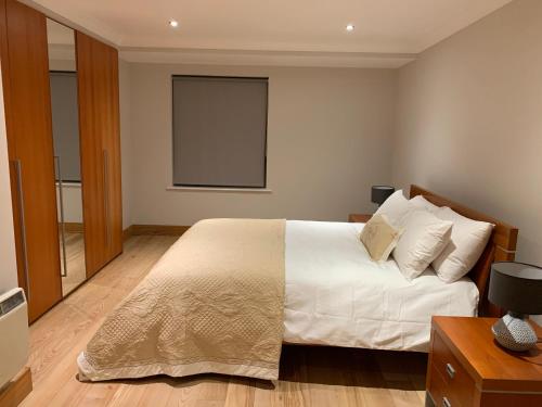 a bedroom with a white bed and a window at Killarney Town Apartment in Killarney