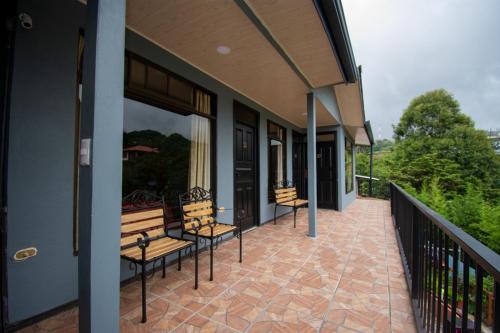 a porch with benches on a building at Cabinas Eddy B&B in Monteverde Costa Rica