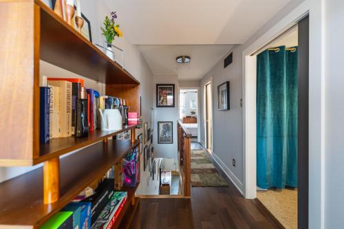 a hallway with wooden bookshelves and a hallway with a hallway at Bedroom in thoughtfully decorated East Passyunk home (South Philadelphia) in Philadelphia