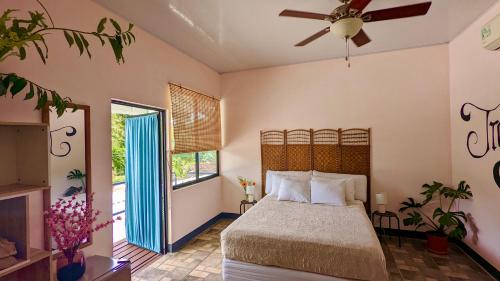 a bedroom with a bed and a ceiling fan at Nova Beautiful boutique hotel Manuel Antonio in Manuel Antonio