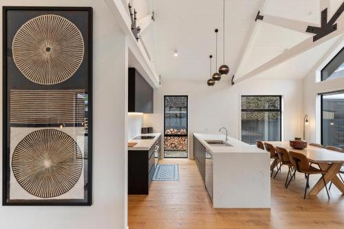 una cucina e una sala da pranzo con pareti bianche e pavimenti in legno di Luxe Arrowtown Home ad Arrowtown
