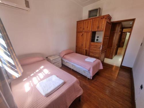 a small bedroom with two beds and a dresser at La Gran Posada in Ciudad Lujan de Cuyo