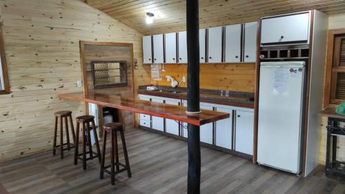 eine Küche mit einer großen Holztheke und Stühlen in der Unterkunft CASA TEMPORADA SANTO ANTONIO in Urubici