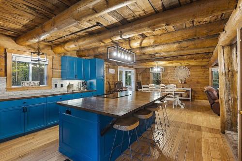uma cozinha com armários azuis e uma sala de jantar em NEW!! Entire Log Home with *PRIVATE Hot Tub em Thornton