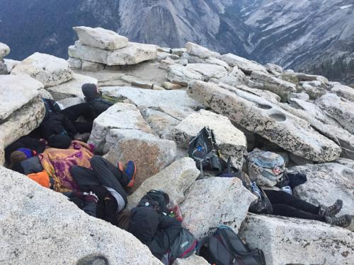 a group of people laying on rocks on a mountain at Yosemite Bug Rustic Mountain Resort in Midpines