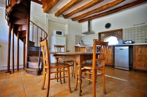 une cuisine avec une table et des chaises en bois dans l'établissement Domaine de Matounet, à Bridoré