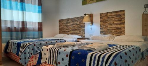 dos camas sentadas una al lado de la otra en una habitación en Hostal Brisa Marina, en Paracas