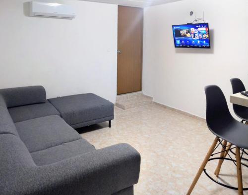een woonkamer met een bank en een tv bij El Depa del Puerto in Cancun
