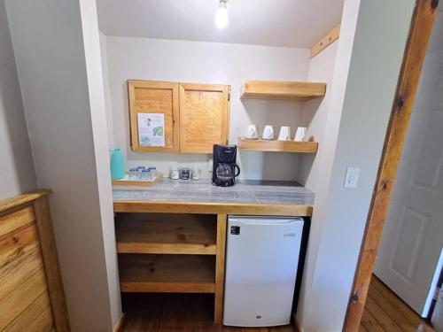 a small kitchen with a counter and a refrigerator at The Odyssey Resort Utila in Utila
