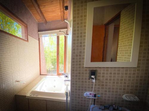 トゥヌヤンにあるCaminos De Uco - posada de campo-のバスルーム(バスタブ、シンク付)、窓が備わります。