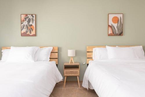 two beds in a bedroom with white sheets at Cozy 2 bedroom condo walking distance from the beach in Ocean Shores