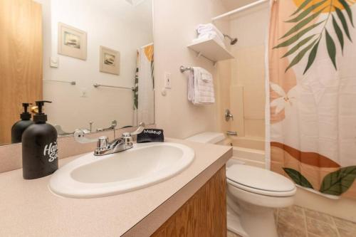 y baño con lavabo y aseo. en Cozy 2 bedroom condo walking distance from the beach en Ocean Shores