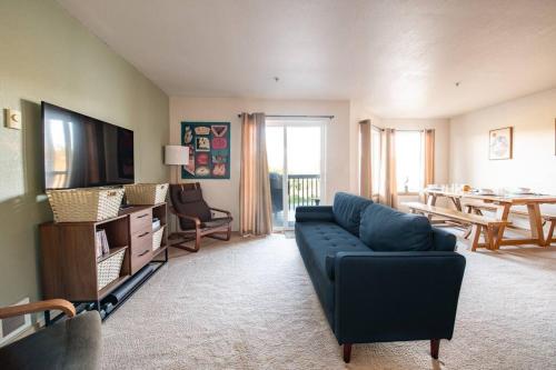 a living room with a blue couch and a table at Cozy 2 bedroom condo walking distance from the beach in Ocean Shores
