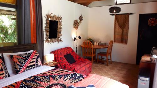 a bedroom with a bed and a chair and a table at Quirky Woods - Glamping Cabins at Maketu in Maketu