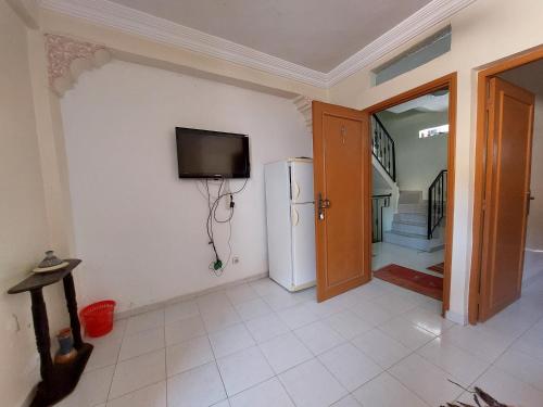 um quarto com um frigorífico e uma televisão na parede em Samsat House Apartment Taghazout em Taghazout