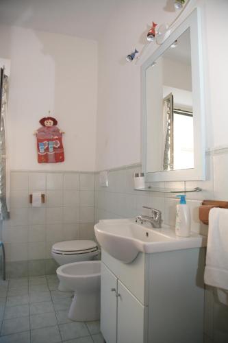 a bathroom with a sink and a toilet and a mirror at La Terrazza in Tuscania