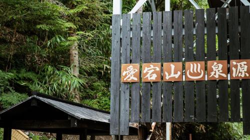 a sign with asian writing on it next to trees at KAMENOI HOTEL Arima in Kobe