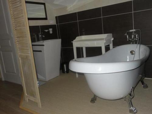 ein Badezimmer mit einer weißen Badewanne und einem Waschbecken in der Unterkunft Gîte Charroux - Allier, 4 pièces, 7 personnes - FR-1-489-271 in Charroux-dʼAllier