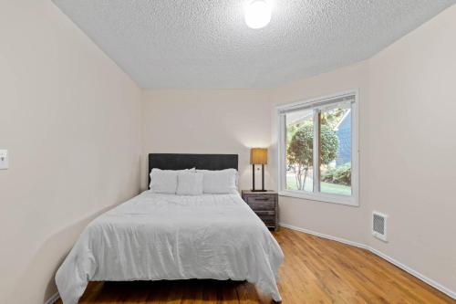 a white bedroom with a bed and a window at A place to CHILL! in Portland