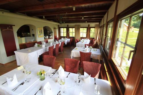 a dining room with white tables and red chairs at Hotel Staribacher Südsteiermark in Leibnitz