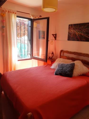 a bedroom with a red bed and a window at Alquilo casa dúplex!!! in Necochea