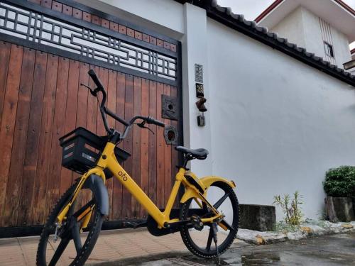 una bicicleta amarilla estacionada frente a un garaje en Omotenashi House of Santa Rosa City Laguna, en Caingin