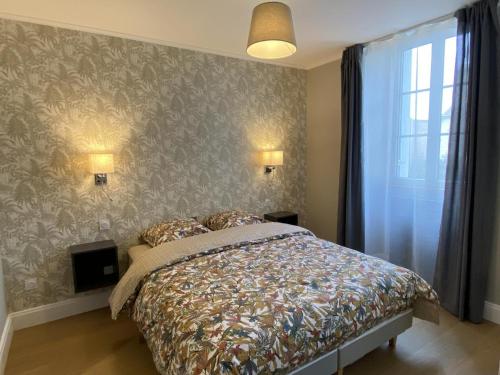 ein Schlafzimmer mit einem Bett und einer Wand in der Unterkunft Appartement cosy au cœur de Vichy, proche thermes et commerces, tout inclus, idéal 2 pers. + options - FR-1-489-364 in Vichy