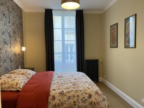 a bedroom with a bed and a window at Appartement Équipé au Cœur de Vichy – Confort et Praticité - FR-1-489-366 in Vichy