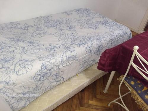 Una cama con una manta azul y blanca. en Dpto cómodo, céntrico a 3 cuadras de la playa y casino en Mar del Plata