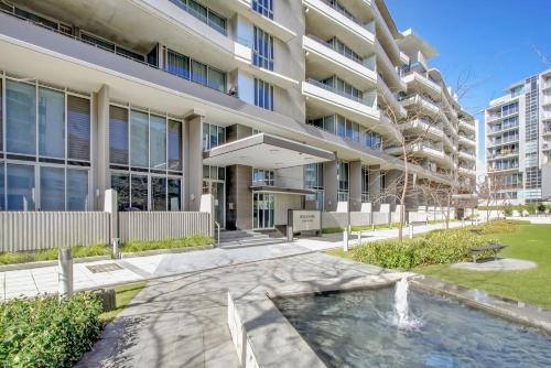 an apartment building with a fountain in front of it at Realm 12 in Canberra