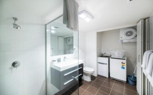 a bathroom with a sink and a toilet and a mirror at Century 23 Griffith in Canberra