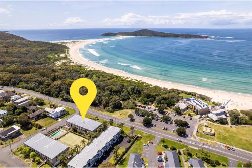 an aerial view of a beach with a yellow marker at The Dunes15 fabulous unit with pool tennis court and across the road to the beach in Fingal Bay