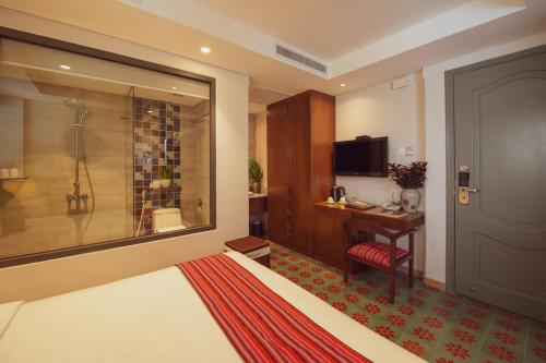 a hotel room with a bed and a desk and a television at Au Lac Legend Hotel in Ho Chi Minh City