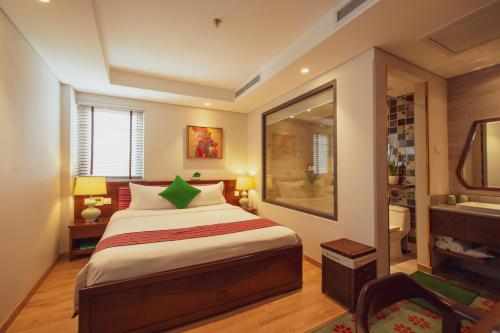 a bedroom with a large bed and a bathroom at Au Lac Legend Hotel in Ho Chi Minh City