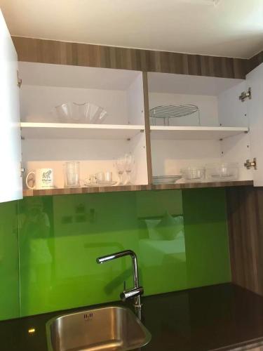 a kitchen with a sink and a green wall at The Beach by Glitter House in Kata Beach