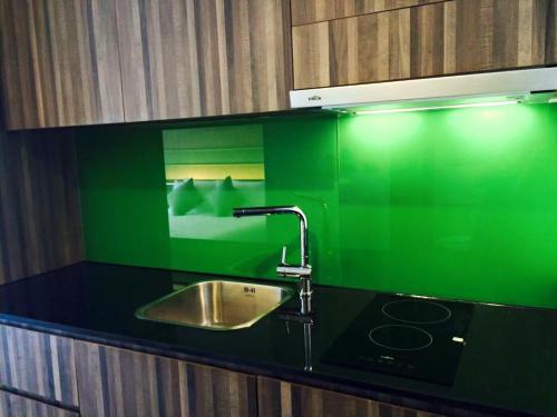 a kitchen with a sink and a green counter top at The Beach by Glitter House in Kata Beach