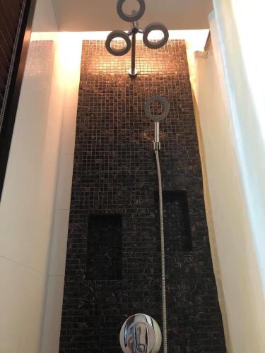a shower in a building with a brick wall at The Beach by Glitter House in Kata Beach