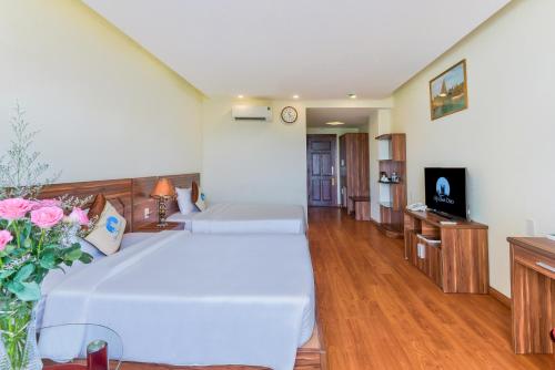a large bedroom with two beds and a television at Sky Beach D20 Nha Trang in Nha Trang