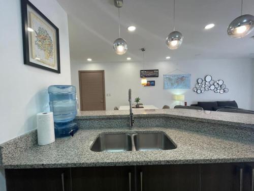 a kitchen counter with a sink with a bottle of water at Condominio de lujo in San Pedro Sula