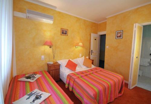 a hotel room with two beds in a room at Cit'Hotel Le Mirage in Istres