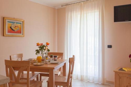 a dining room with a table and chairs and a window at Residence Hotel Raggio Di Luce in Ponte di Legno