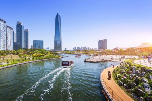 a boat traveling down a river in a city at Holiday Inn Incheon Songdo by IHG in Incheon