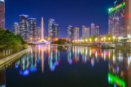 a city skyline at night with a river and buildings at Holiday Inn Incheon Songdo by IHG in Incheon