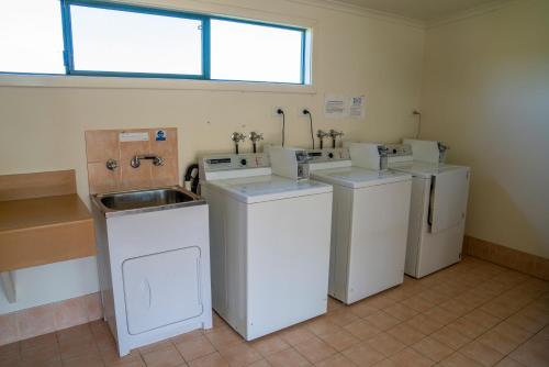 uma lavandaria com três lavatórios e um lavatório em Karri Aura em Denmark