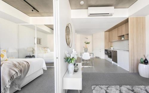 a bedroom and a living room with a bed and a kitchen at Azure 30 in Kingston 