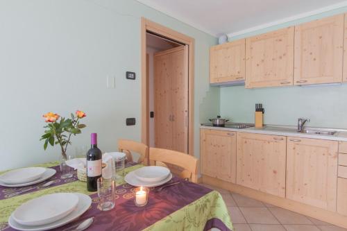 a kitchen with a table with plates and a bottle of wine at Residence Hotel Raggio Di Luce in Ponte di Legno